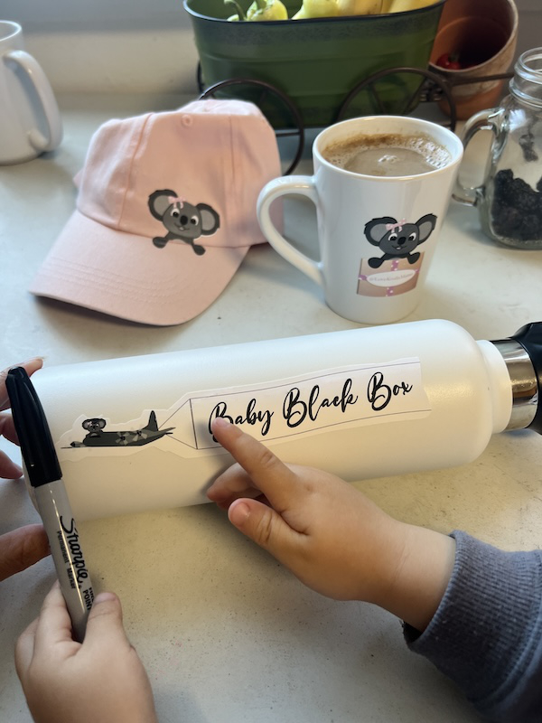 Child's hand pointint at Baby Black Box swag.